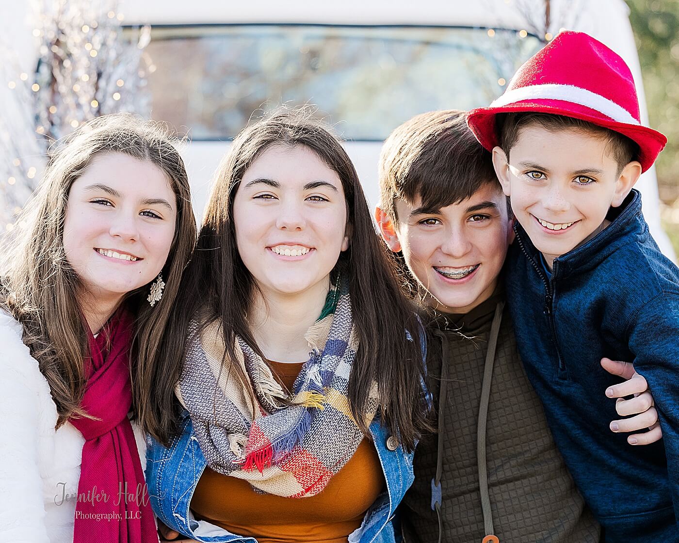 Kids sitting with their arms around each other in a white truck for a Christmas truck family photo session in North East, PA.