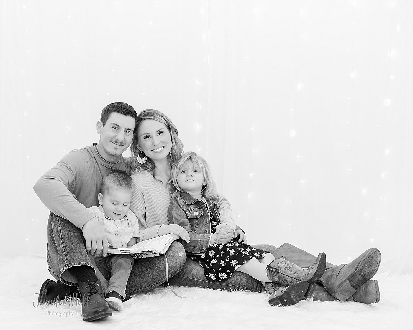 Family sitting on the ground and reading the Bible for family studio Easter photography near Erie, Pa.