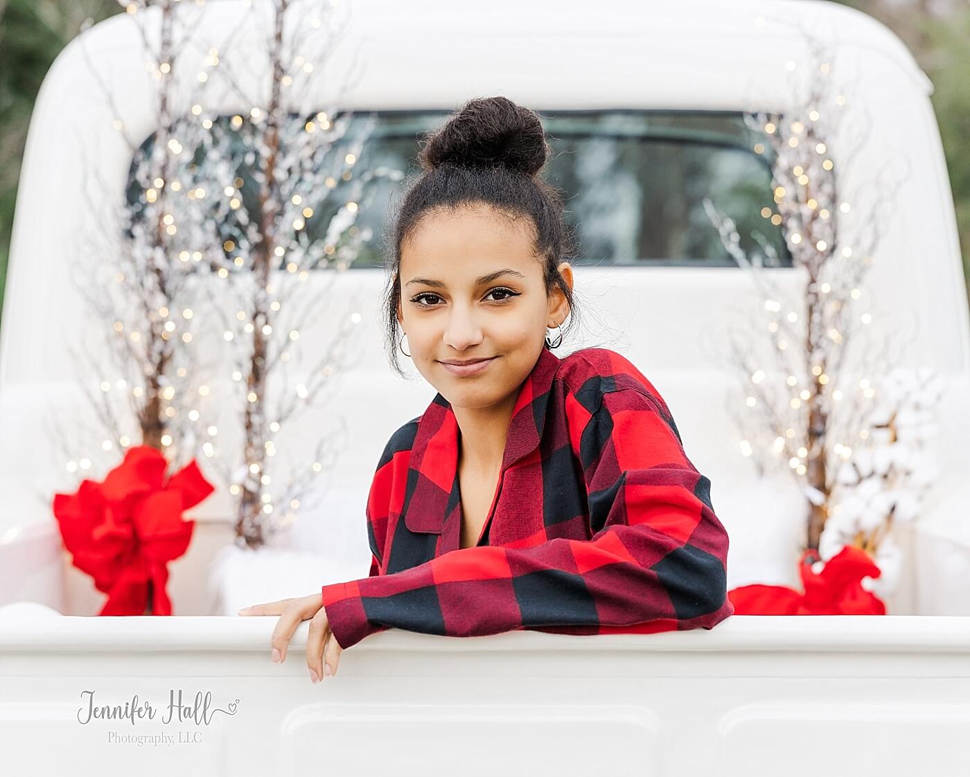 Girl sitting in the back of a white, vintage truck for Christmas truck family photos in North East, PA.