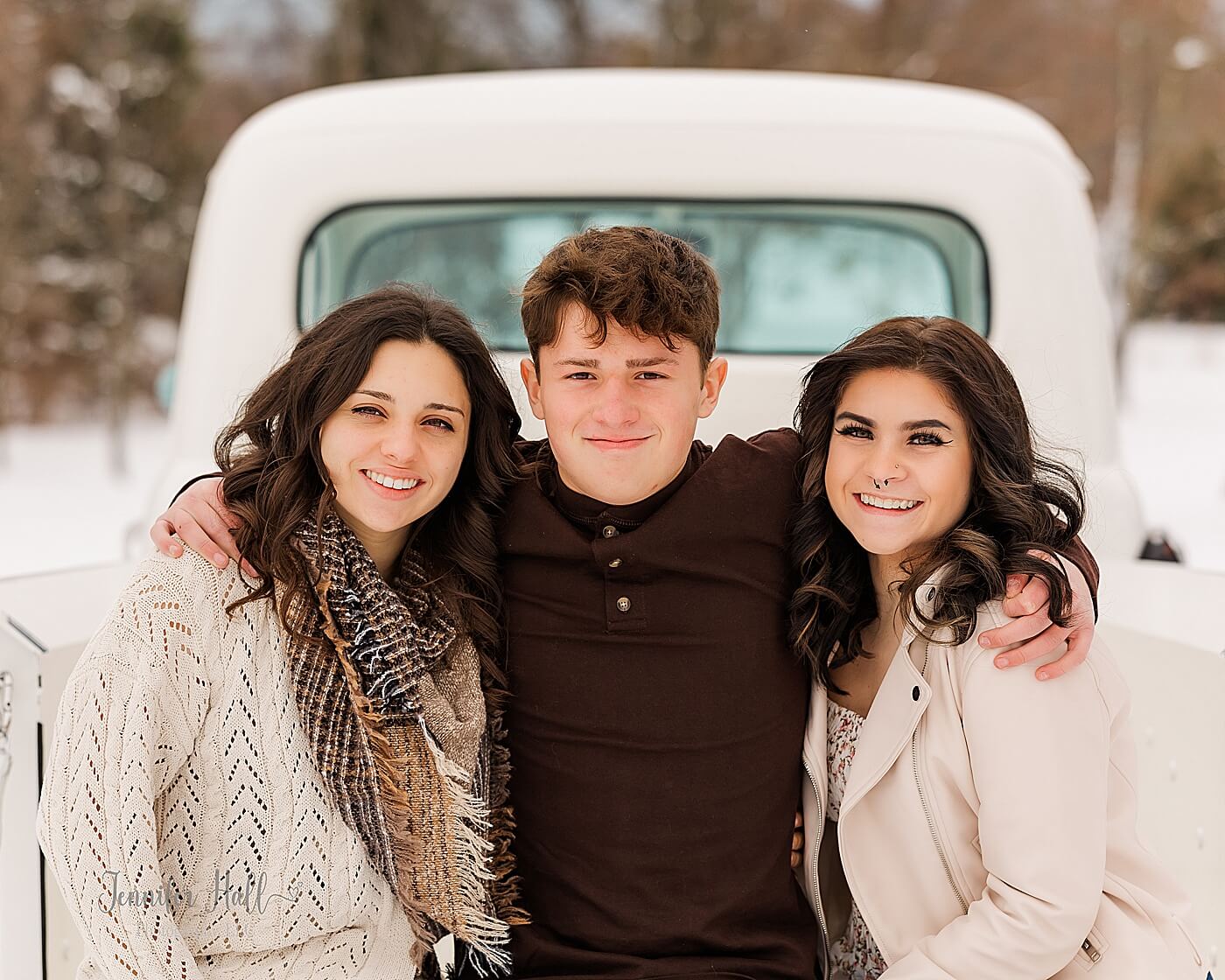 Kids sitting in the back of a Ford truck in the snow for white truck family portraits near Erie, PA.