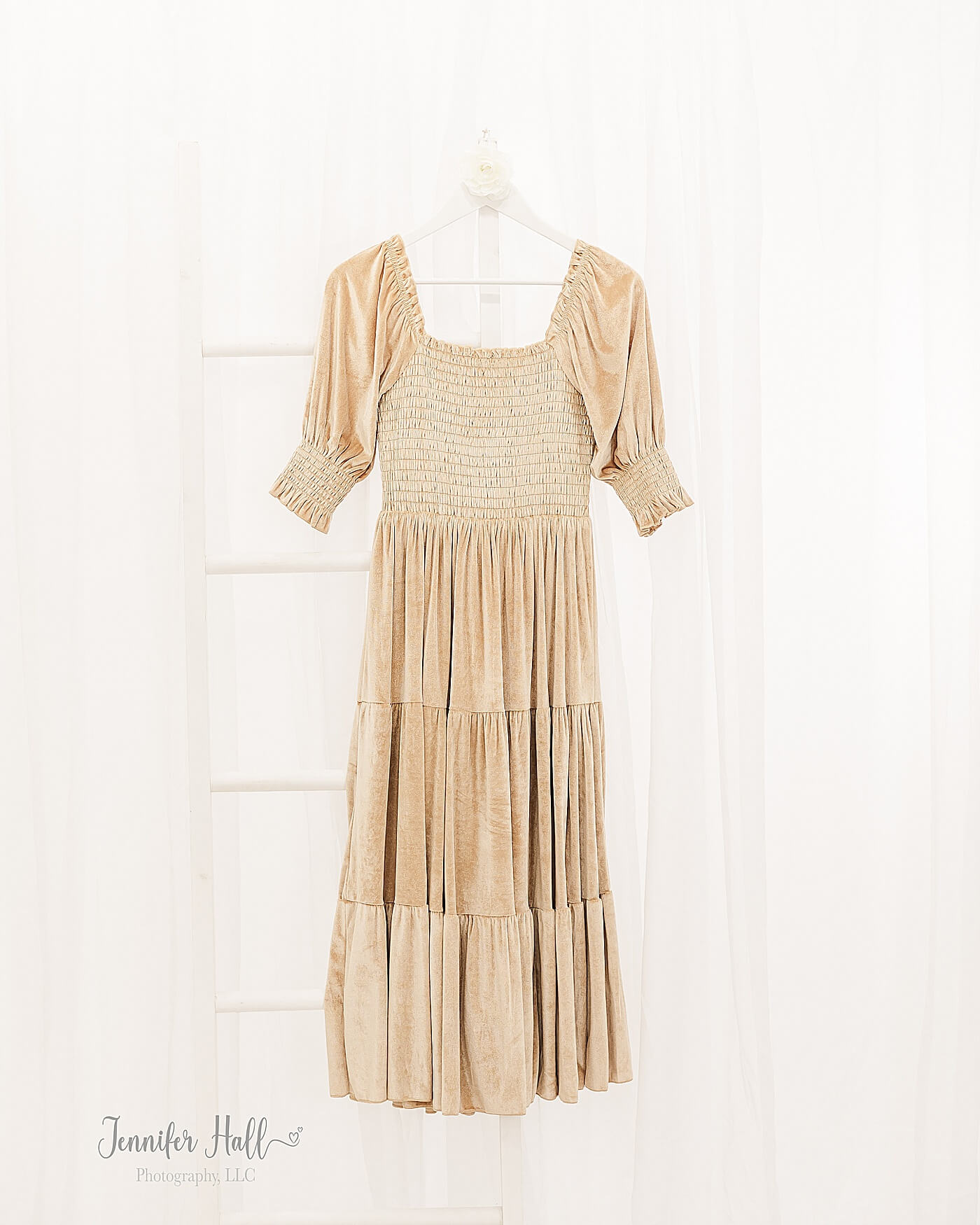 French gold dress hanging up in a portrait session studio to show styling tips for her for a family portrait session.