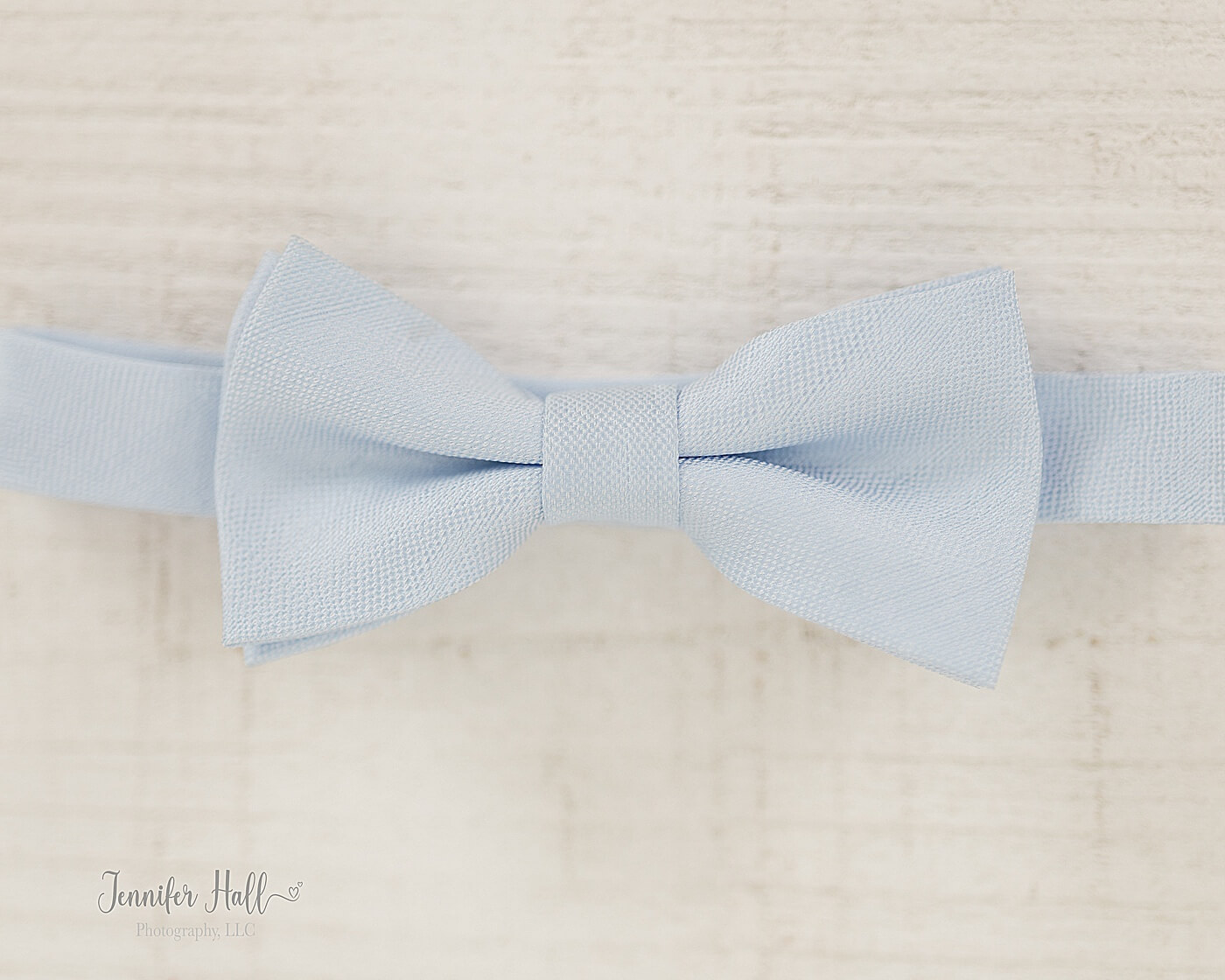 Powder blue tie on a white wooden bench to show an accessory for men.