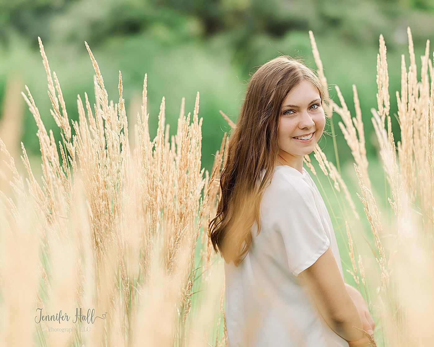 Girl with a white dress shirt standing outdoors in brown, ornamental grass in North East, PA.