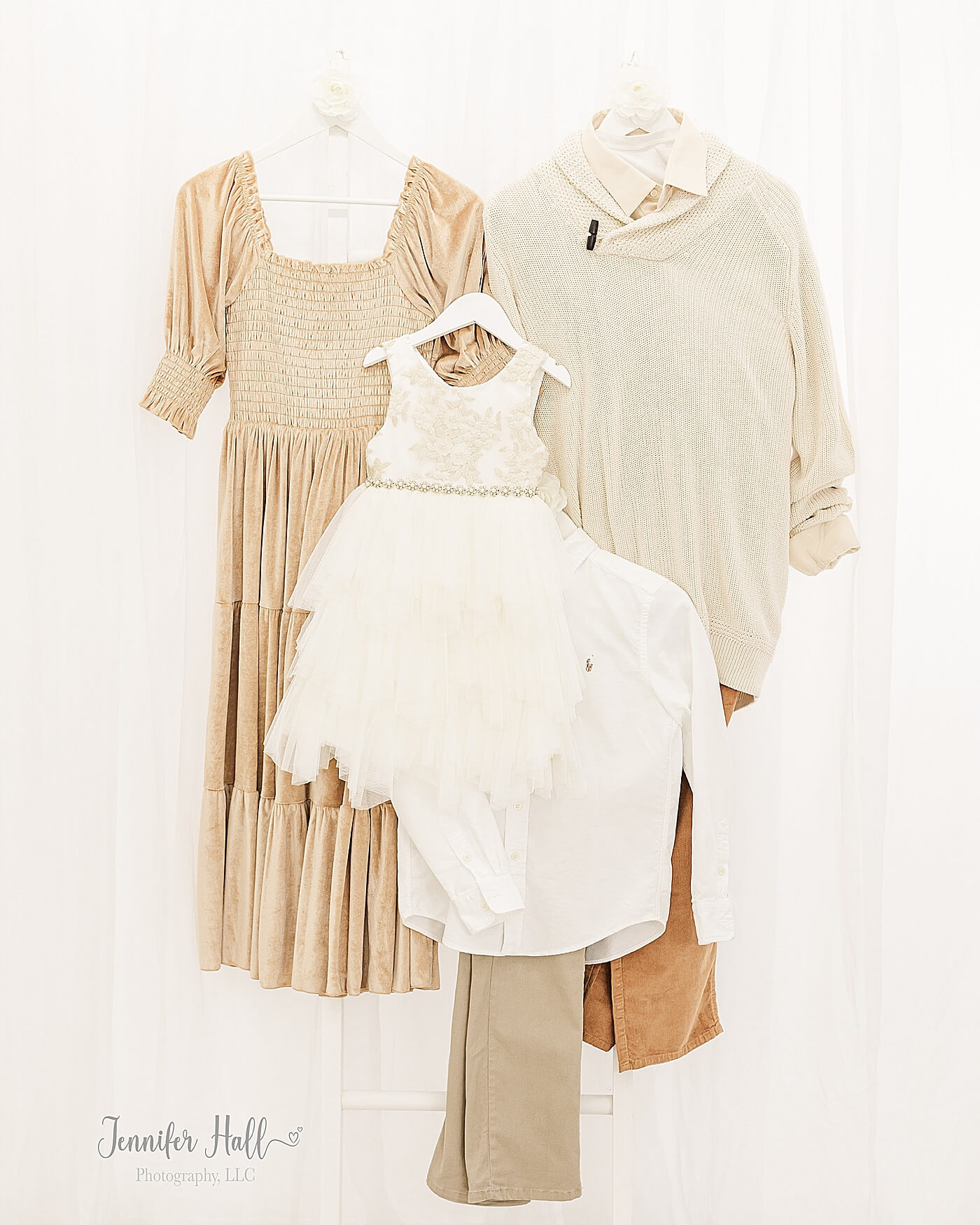 French gold dress; a beige sweater with a beige collared shirt and mustard corduroys; a cream dress for a little girl; and a white collared shirt with tan dress pants hanging on a white ladder for French gold and beige fall family outfits.