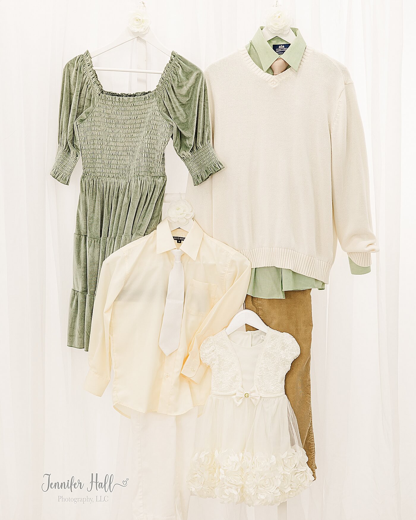 Dusty sage dress; a dusty sage collared shirt with a white sweater and tan corduroys; a cream dress; and a pale-yellow collared shirt with white dress pants hanging on a white ladder for a dusty sage and tan outfit color palette for fall family photos.