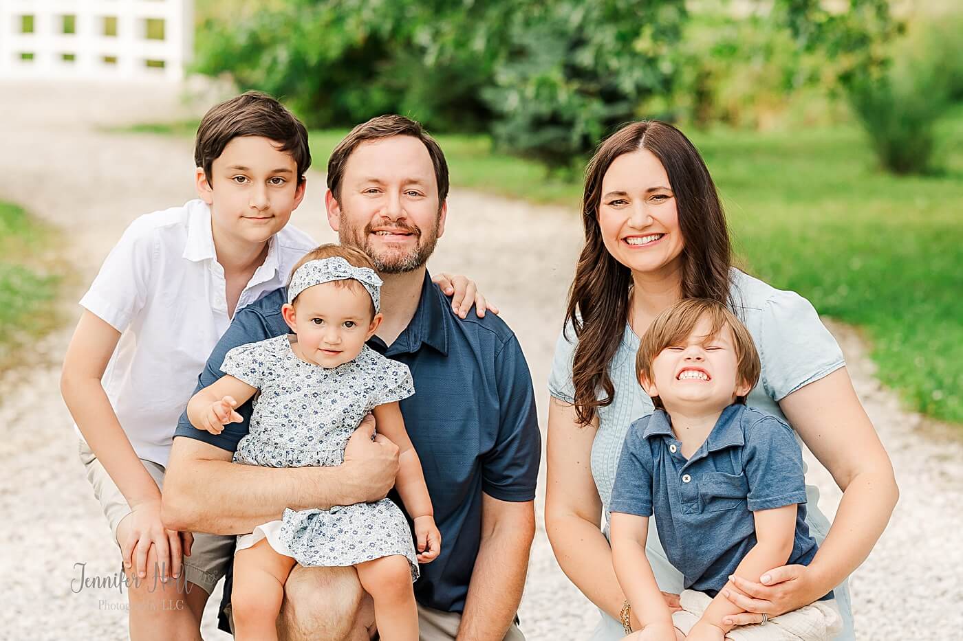 Woman with a blue dress with her family to show a portrait styling tip for women.