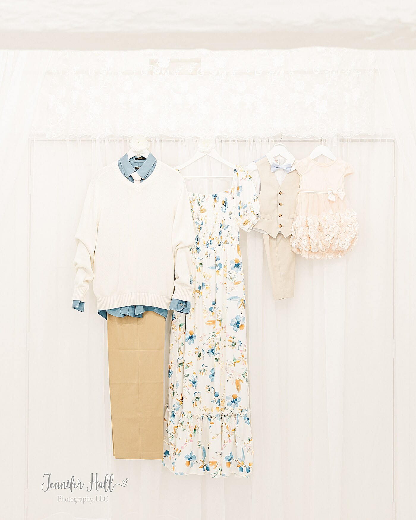 White dress, pewter blue collared shirt with tan khakis and a cream sweater, a vanilla blush dress, and a white collared shirt with a beige suit vest and beige dress pants for family portrait session outfits.