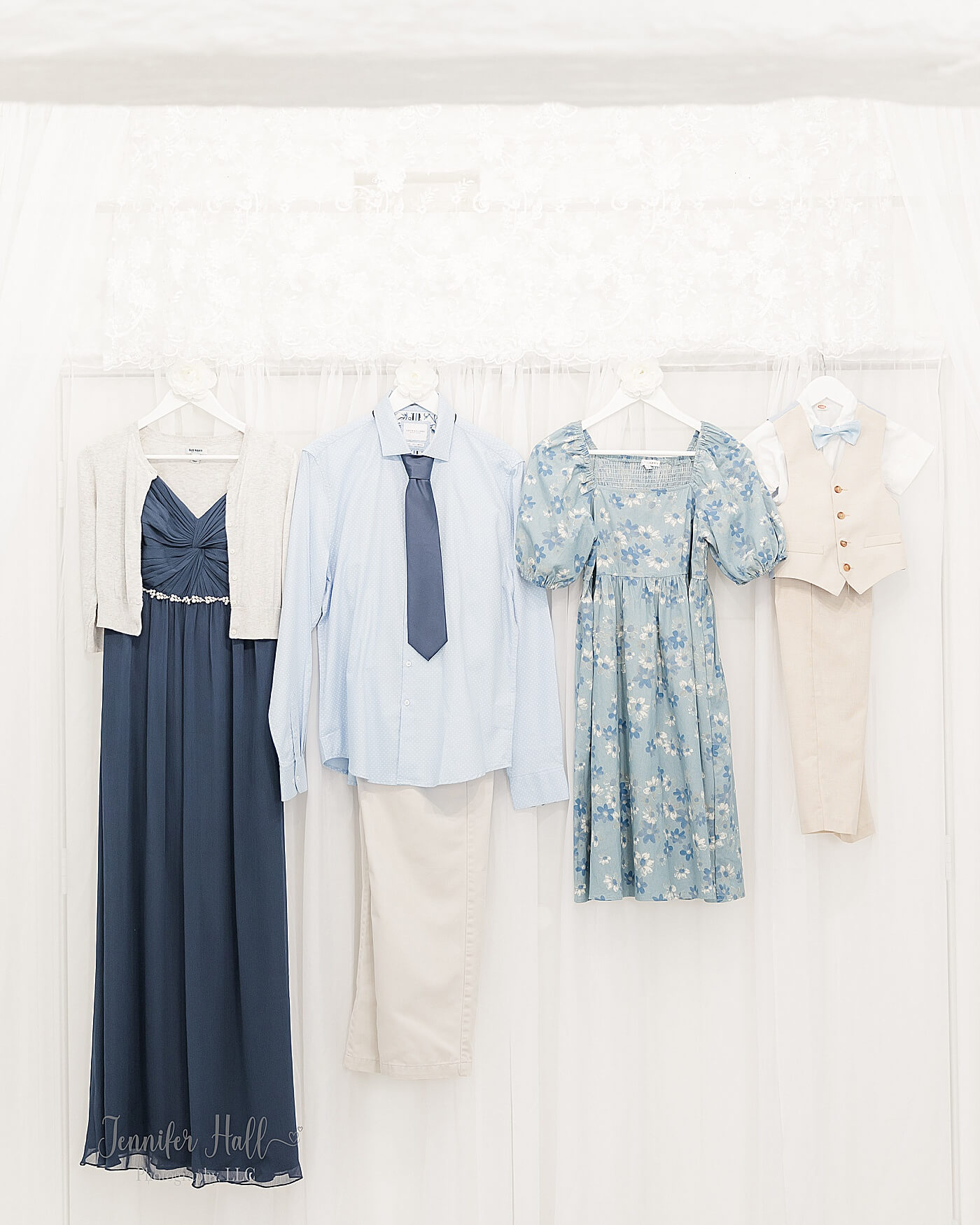 Navy dress, a light sky-blue long-sleeved shirt with beige khakis, a powder blue dress, and a beige vest with dress pants to show what to wear for a family portrait session.