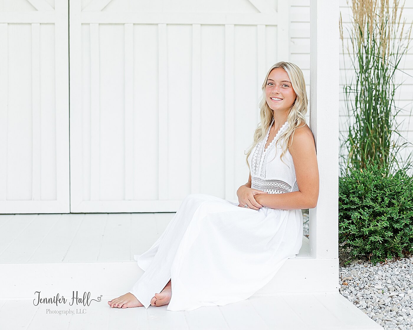 Girl with a long, white dress sitting at an "Outside Grand Entrance," showing a girl outfit for portraits.