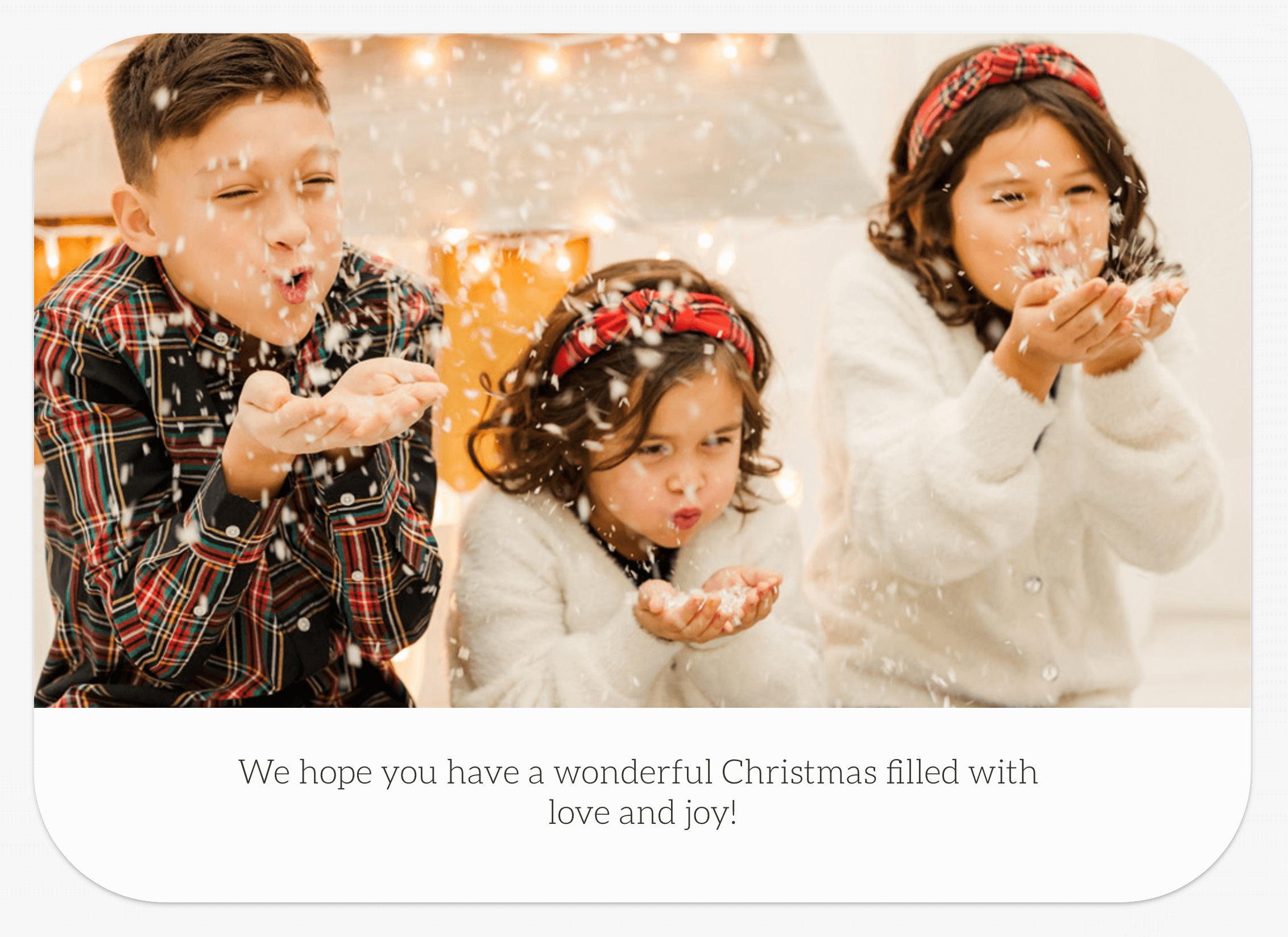 Screenshot of the back of a Christmas card with a picture of kids blowing pretend snow.