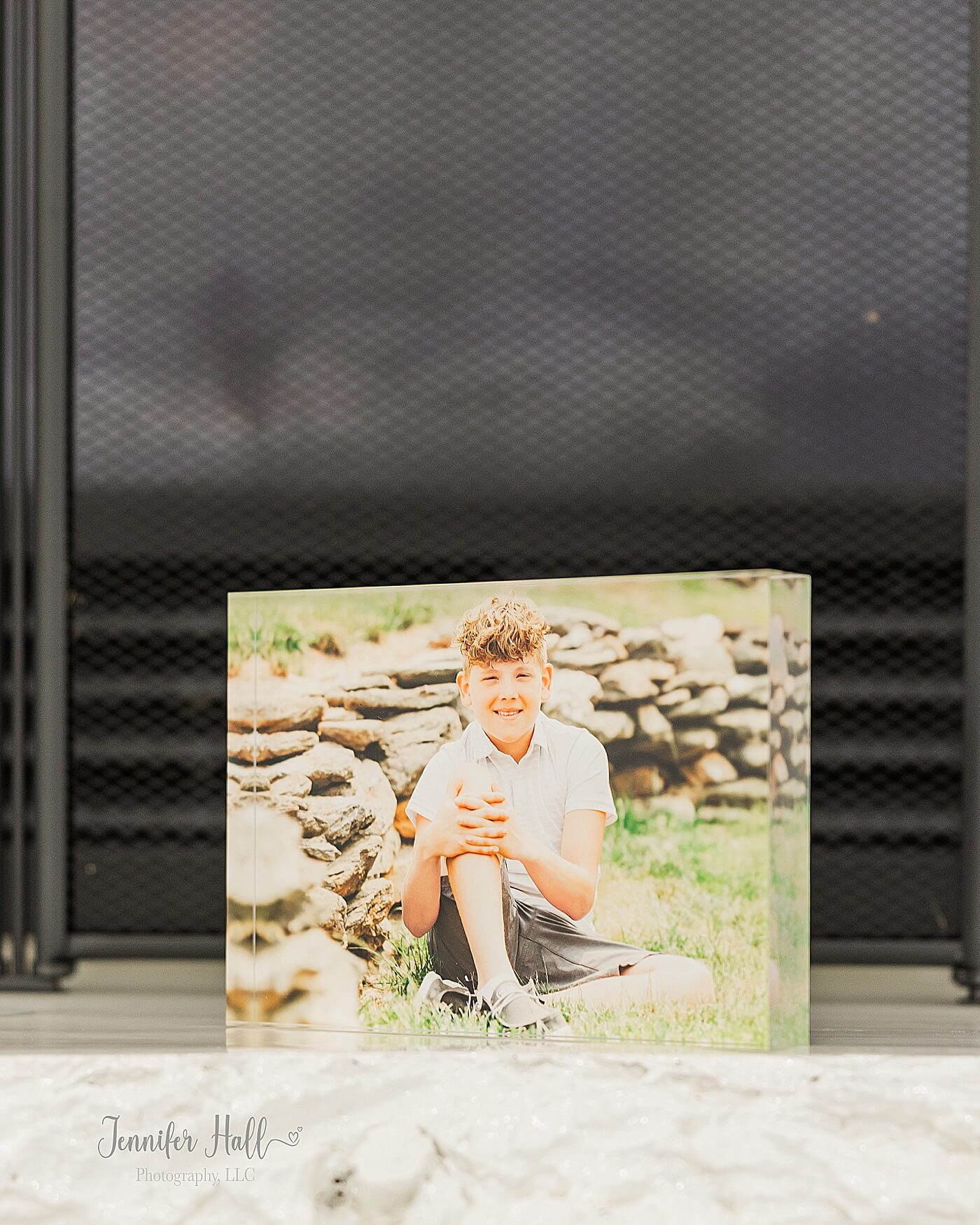 Acrylic block with a photo of a boy by a rock wall outdoors for a family photo gift idea for Christmas.