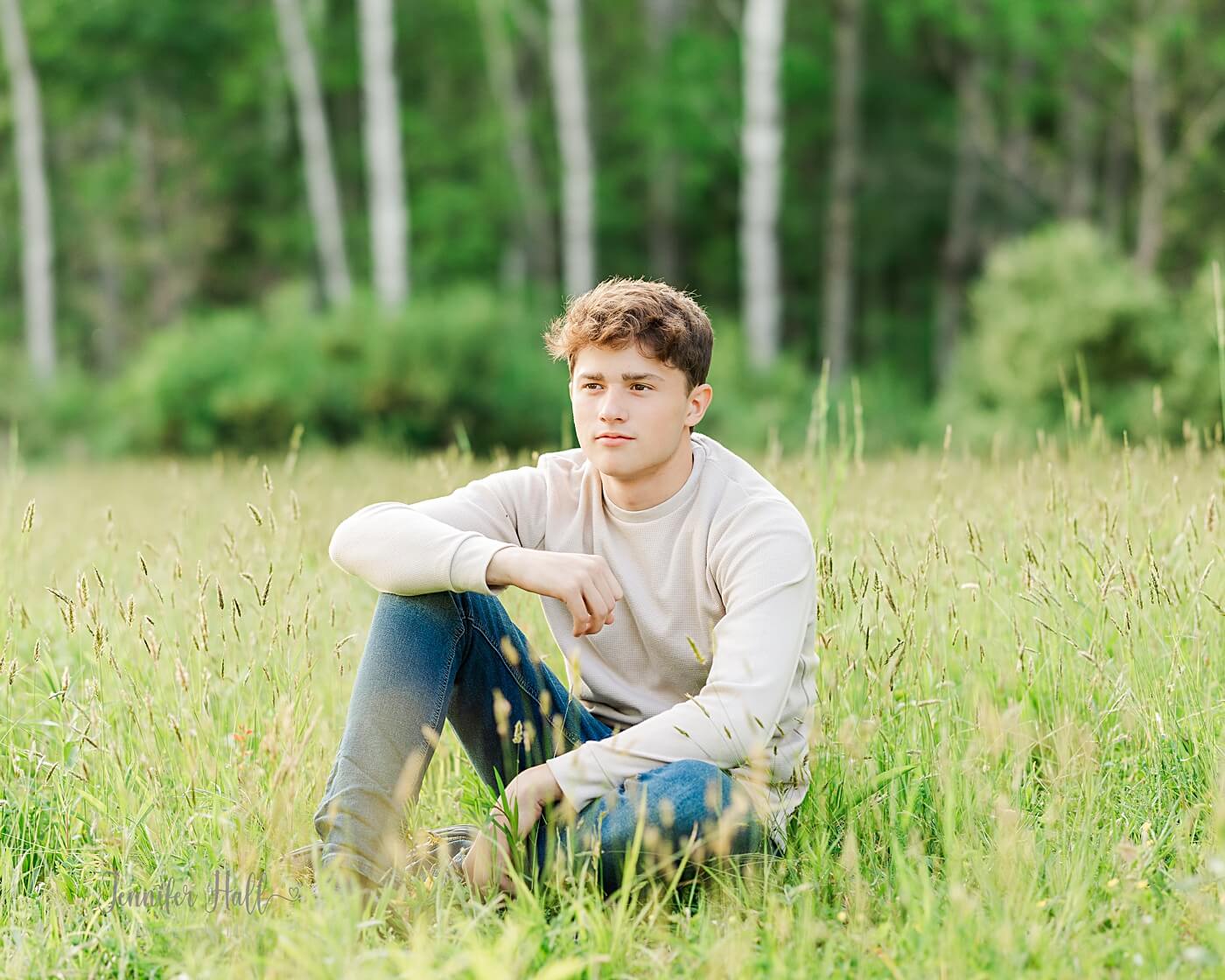 Senior boy with a beige shirt sitting to show a photo styling tip for senior boys.