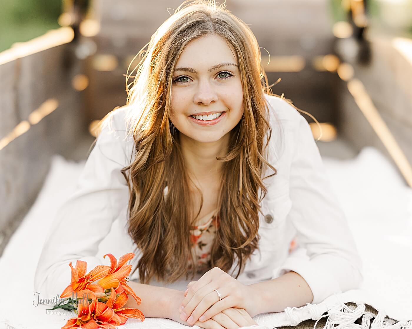 Teen girl on a white blanket outdoors.