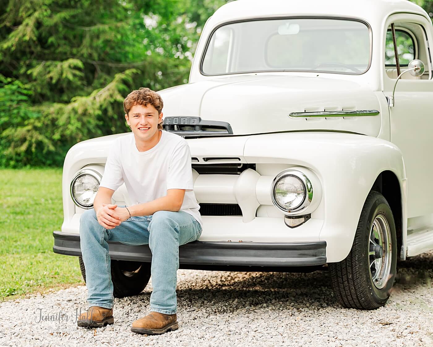Boy sitting on the bumper of a vintage truck in North East, PA.