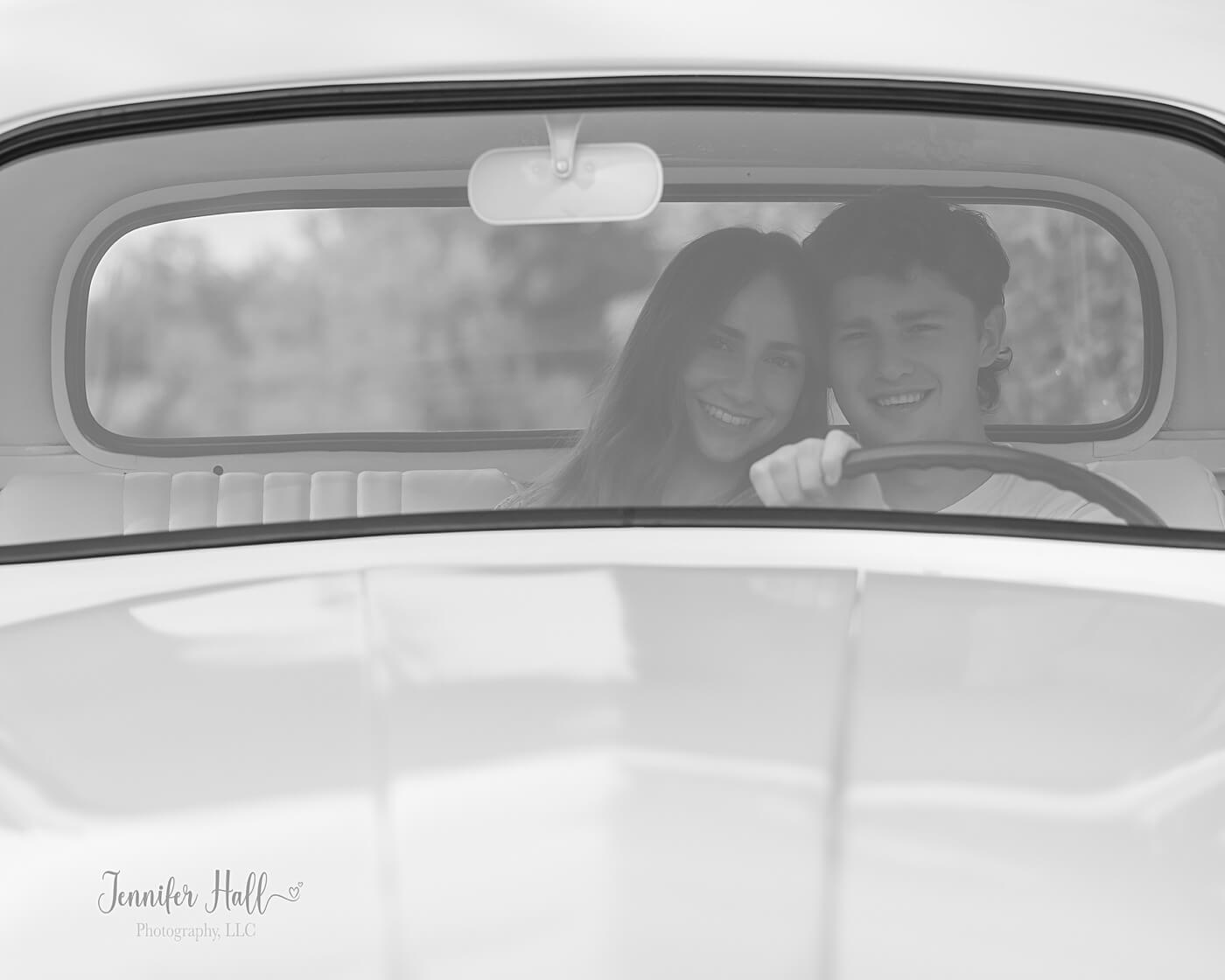 Couple looking through a truck’s front window for timeless couple’s pictures in North East, PA.