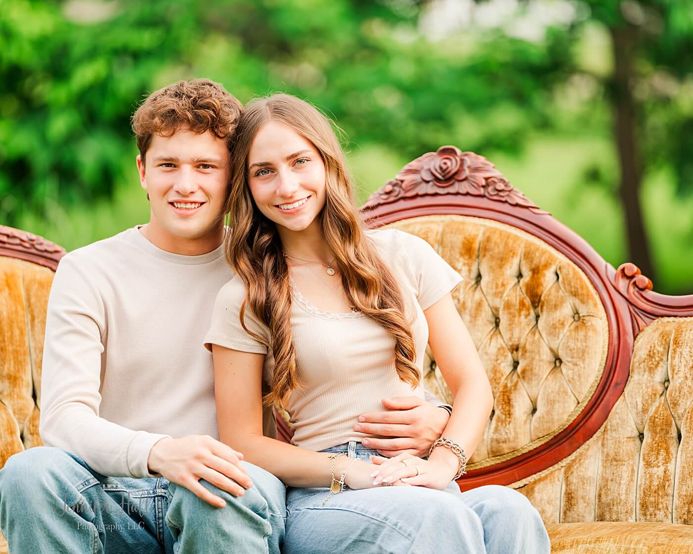 Couple sitting on a beige Victorian couch for timeless couple’s pictures in North East, PA.