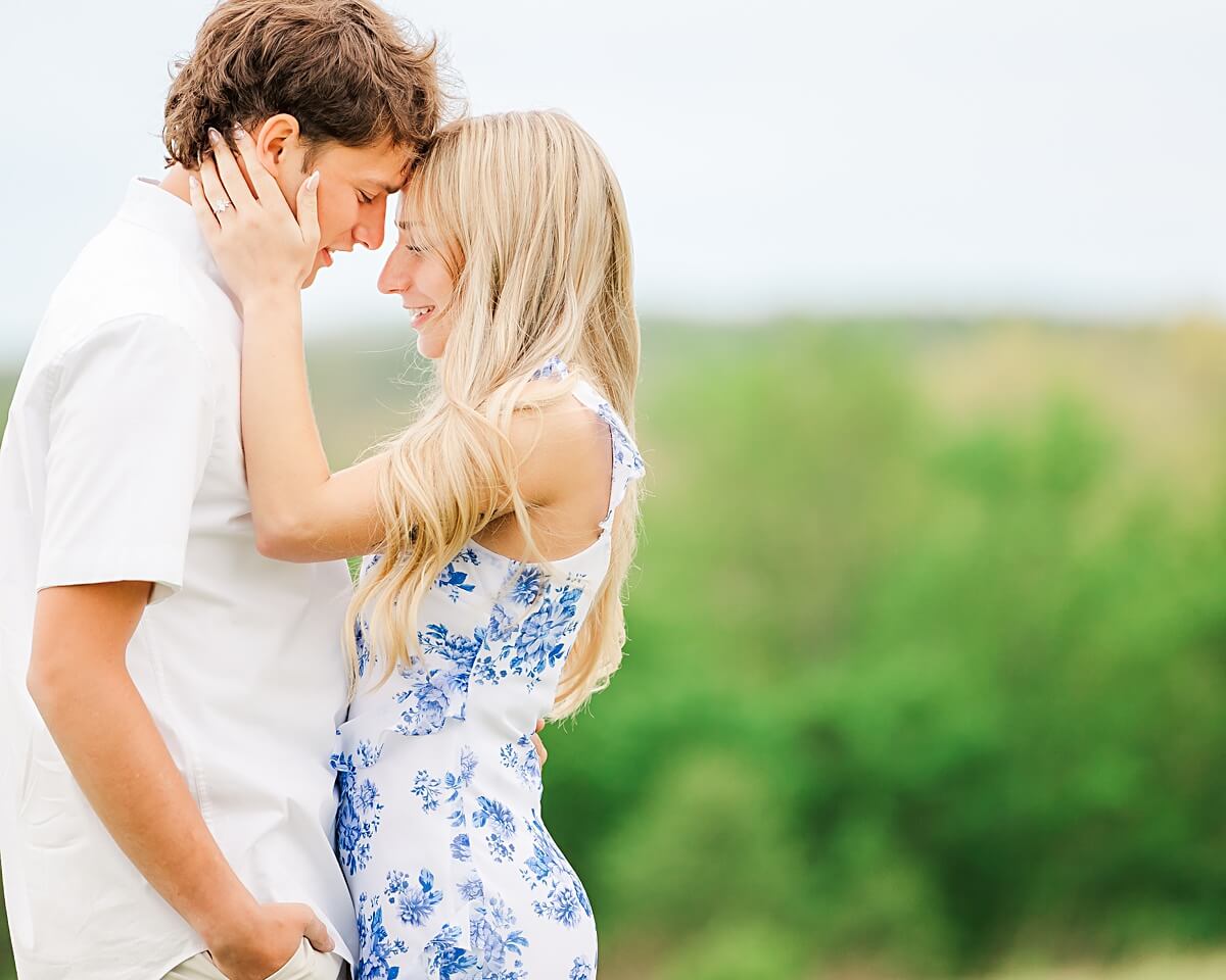 Man and a woman hugging by mountains for engagement photos in Hinsdale, New York.